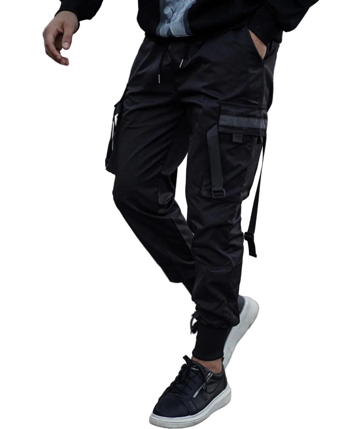 Person wearing black cargo pants and black sneakers on a textured pavement.