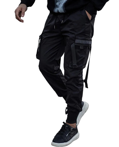 Person wearing black cargo pants and black sneakers on a textured pavement.