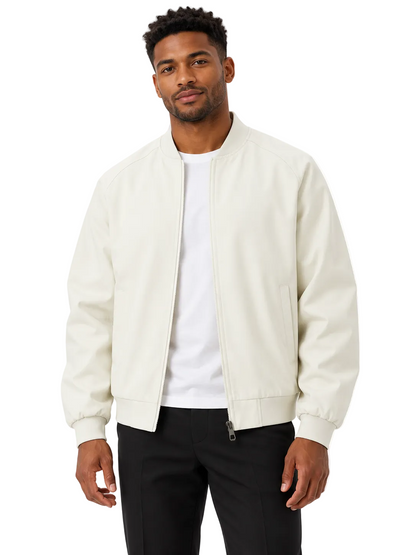 A man wearing a cream-colored leather bomber jacket over a white t-shirt and black pants, standing against a plain white background.
