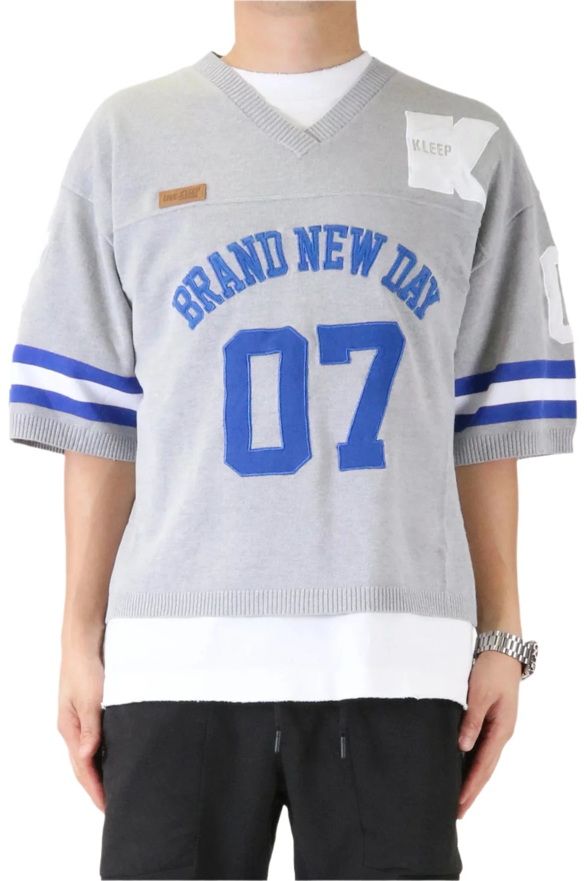 Gray sports jersey with 'Brand New Day 07' text and blue accents worn by a person.