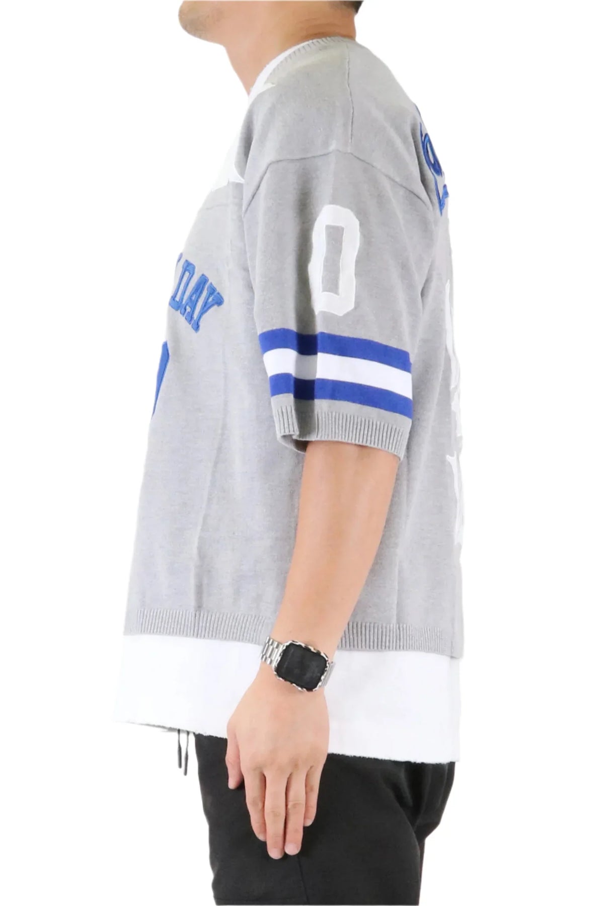 Person wearing a gray sports jersey with blue and white accents on a white background