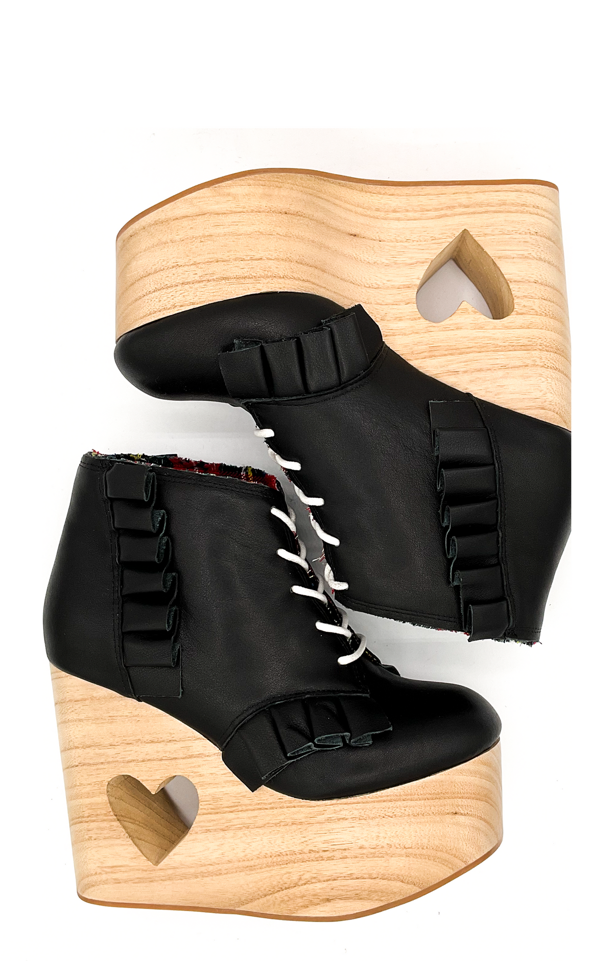 Black wedge boots with wooden soles on a white background