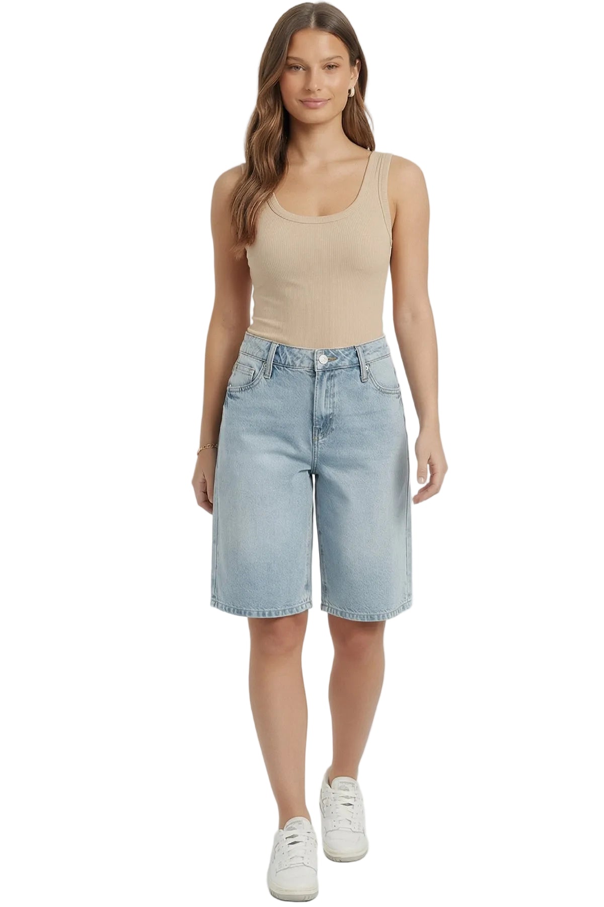 Woman wearing a beige tank top and light blue denim shorts on a white background