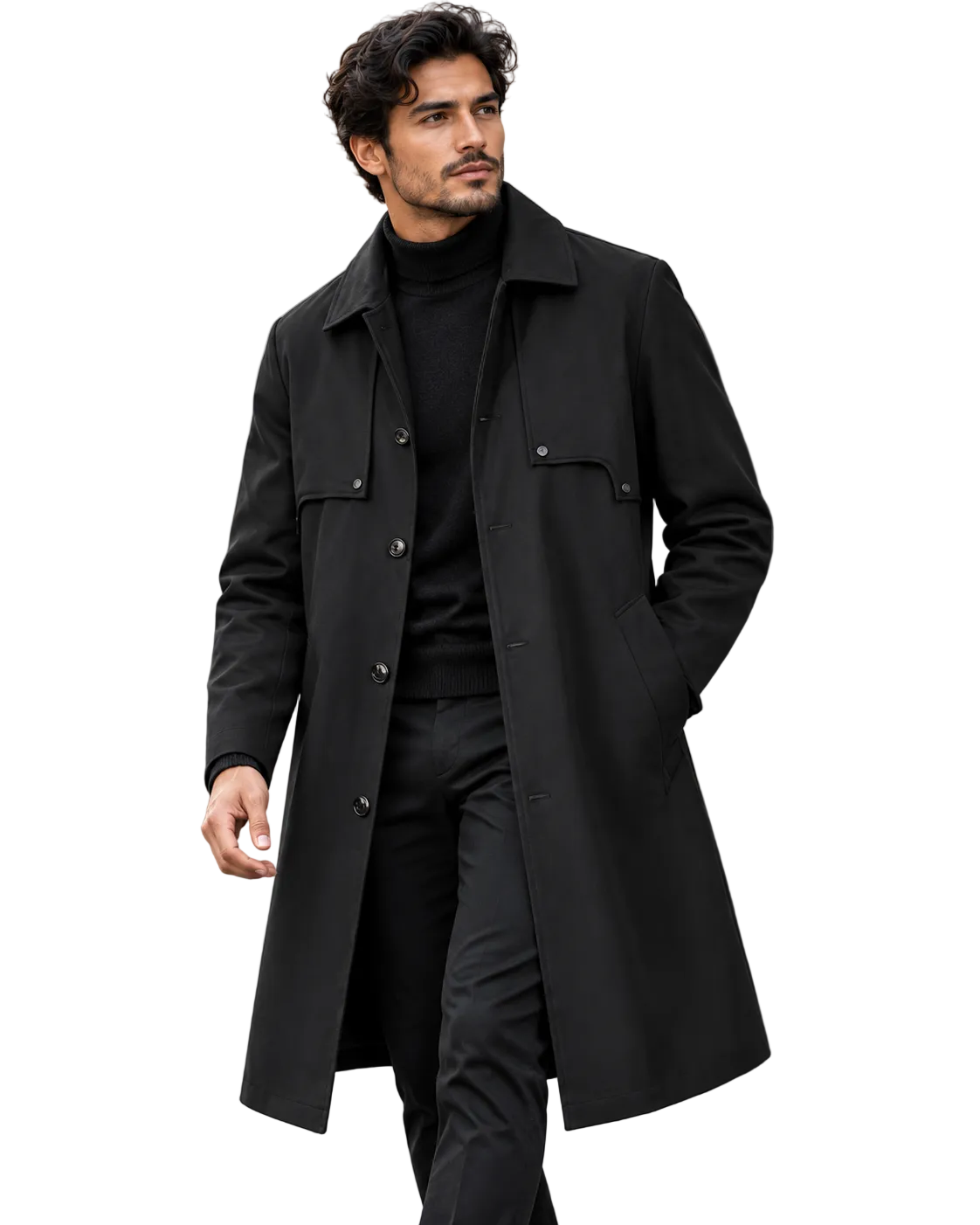 A man wearing a long black wool-blend coat over a black turtleneck and black trousers, walking outdoors on a city street with blurred stone columns in the background.