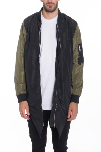 Person wearing a black and olive green long jacket on a white background