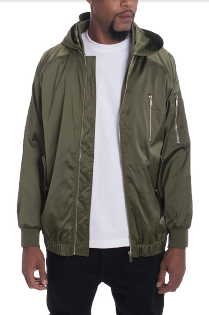 Person wearing a green jacket over a white shirt on a plain background
