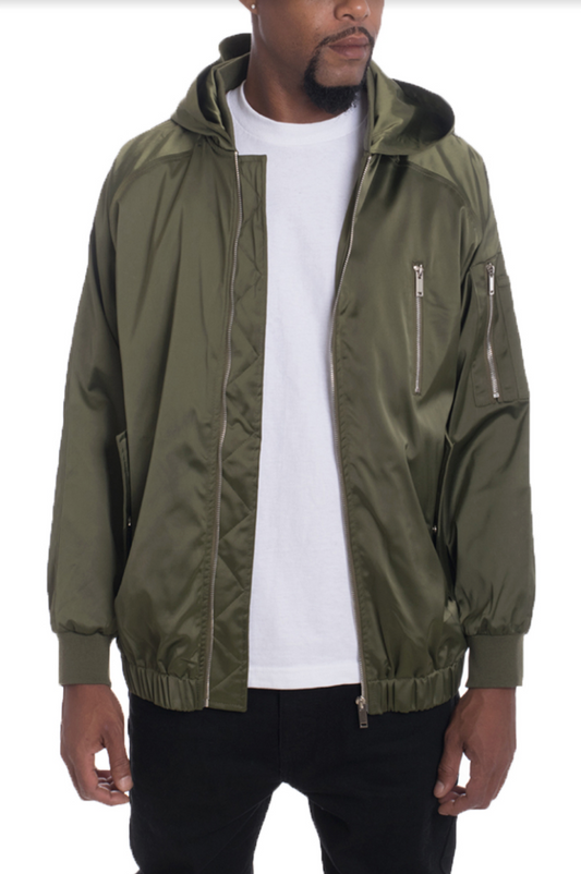 Person wearing a green jacket over a white shirt on a plain background