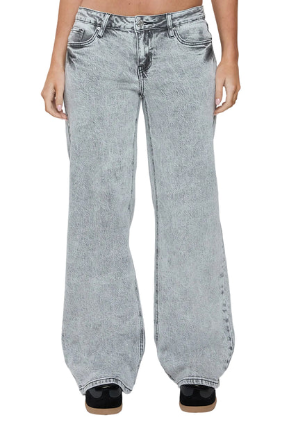 Person wearing light blue acid-wash jeans on a white background