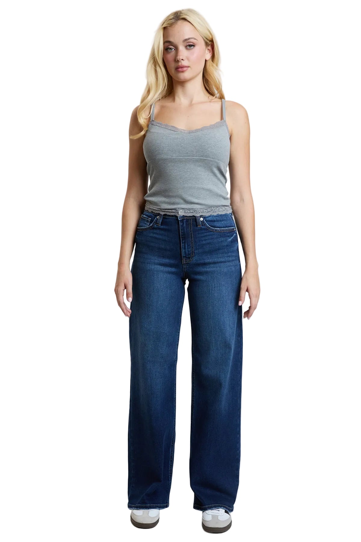 Woman wearing a gray tank top and blue jeans on a white background