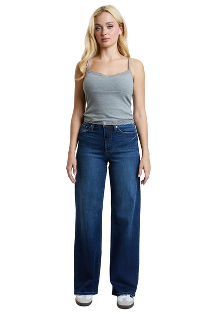 Woman wearing a gray tank top and blue jeans on a white background