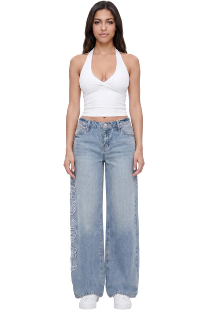 Woman wearing a white halter top and blue jeans on a white background