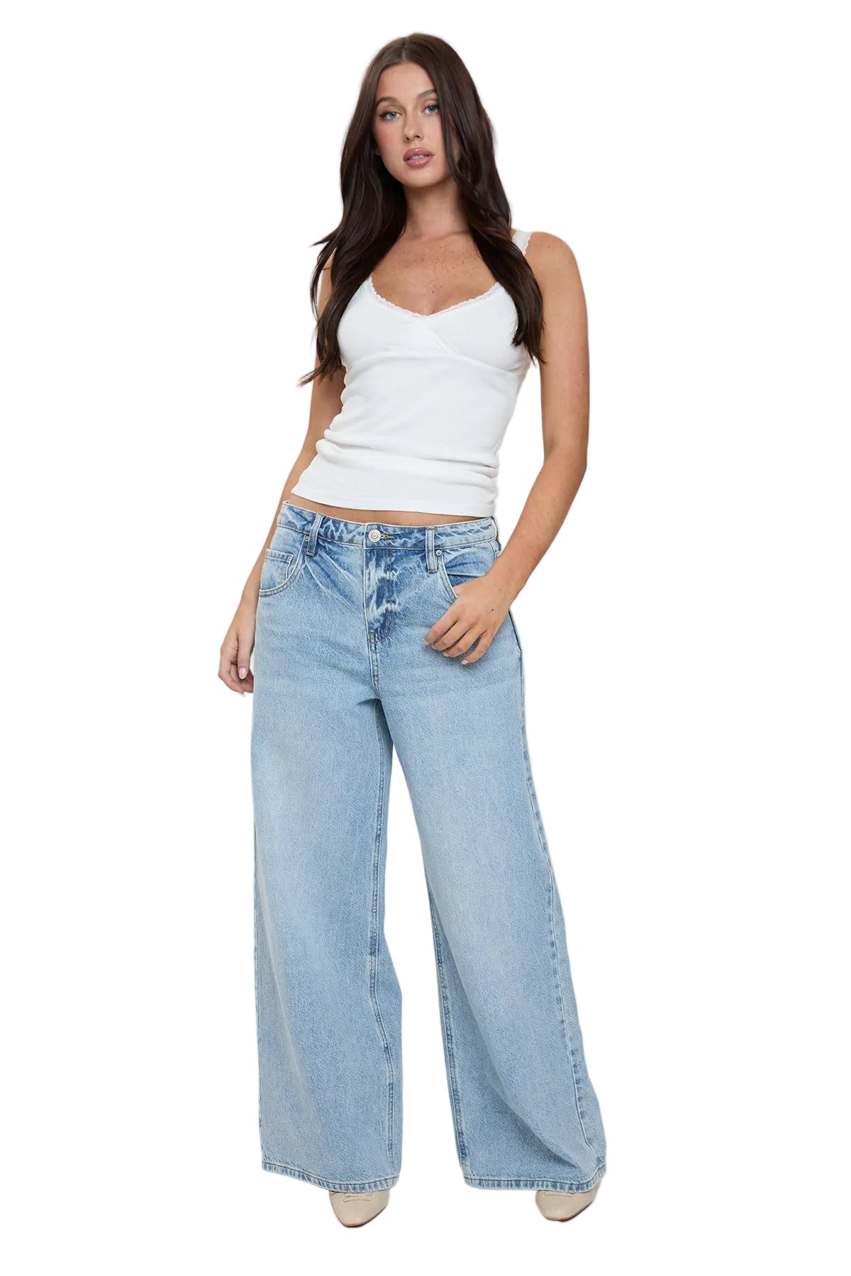 Woman wearing a white tank top and light blue jeans on a plain background