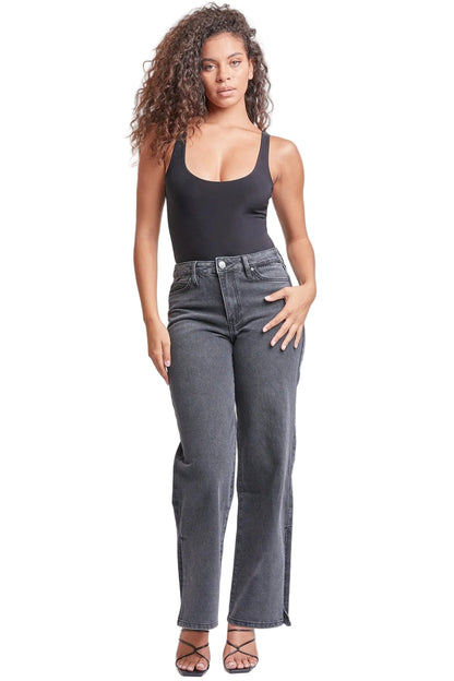 Woman wearing a black tank top and gray jeans on a white background