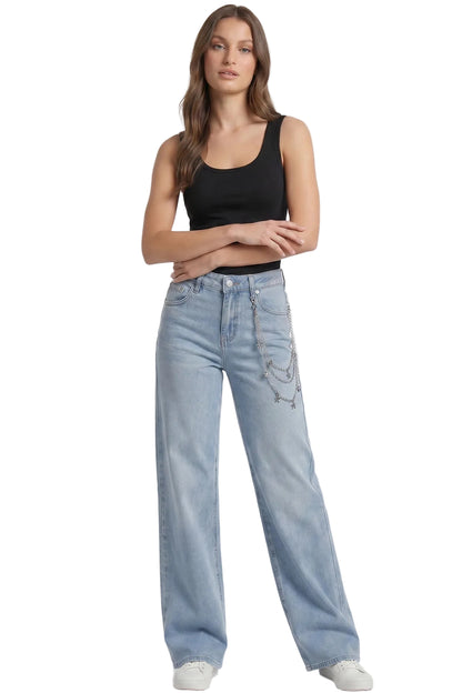 A model wearing a black tank top and light-wash wide-leg jeans with a silver chain detail on the pocket, standing against a plain white studio background.