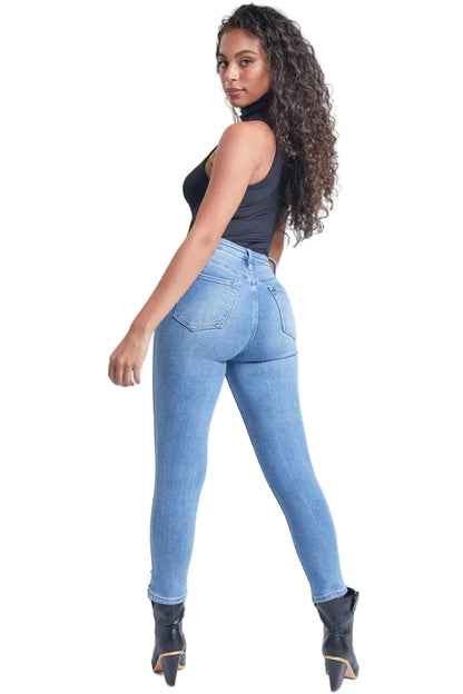 Woman wearing light blue jeans and black top on a white background