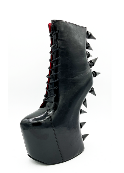 Black high-heeled boot with spikes on a white background