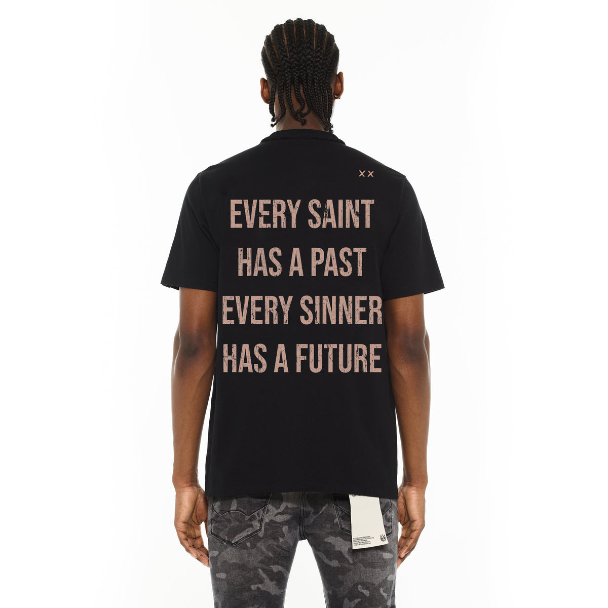 Person wearing a black t-shirt with text on the back, standing against a white background