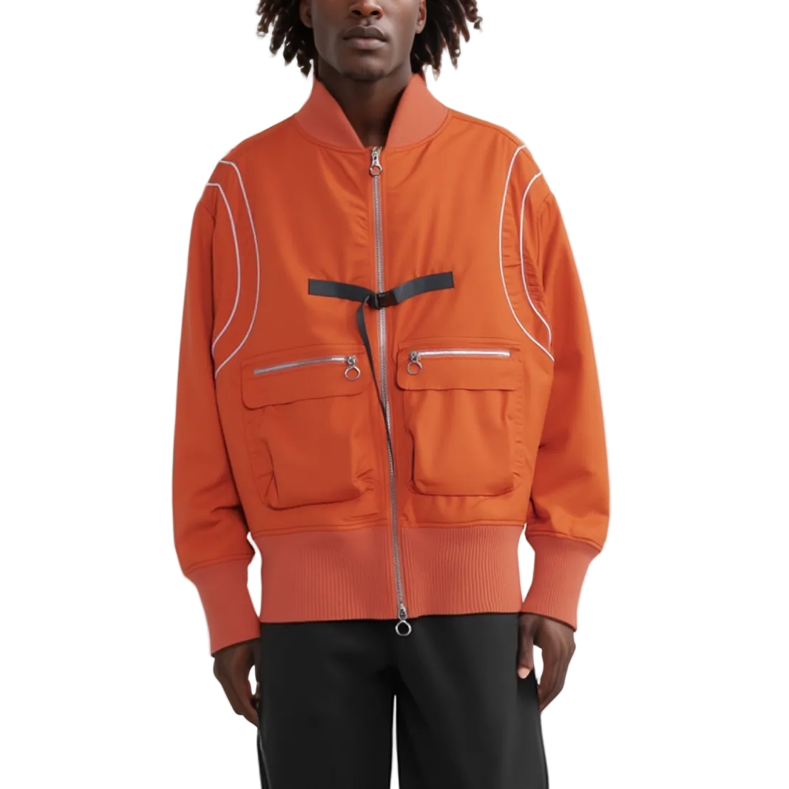 A model wearing a bright orange bomber jacket with white piping details, silver zippers, and a black belt detail at the chest, paired with black pants against a white studio background.