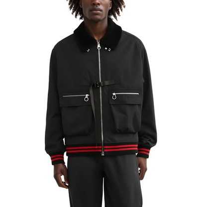 Person wearing a black jacket with red accents on a white background