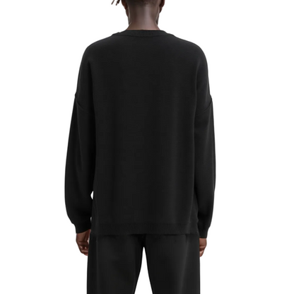 Person wearing a black sweatshirt and pants on a white background