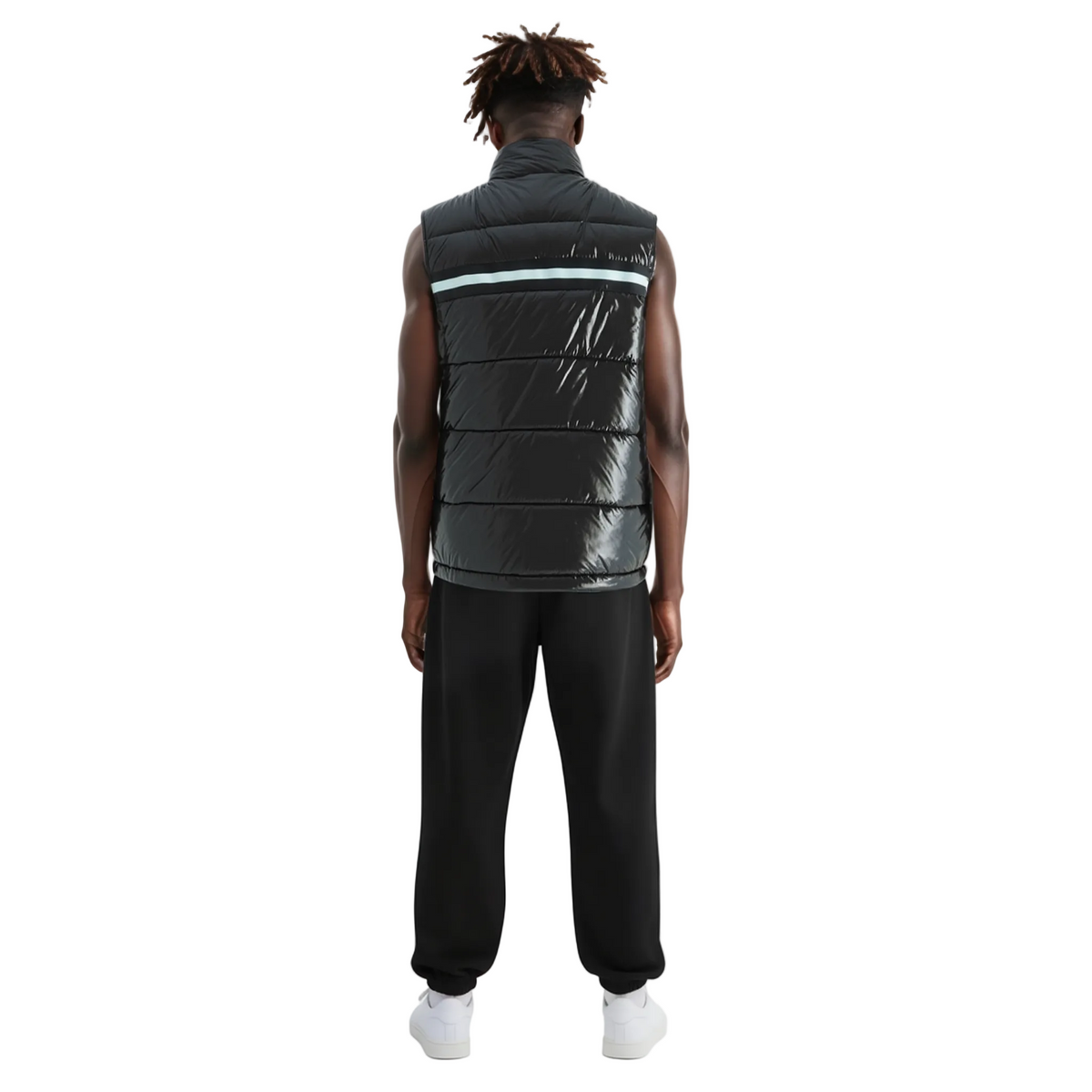 Person wearing a black puffer vest and black pants on a white background