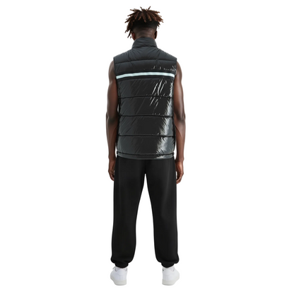 Person wearing a black puffer vest and black pants on a white background