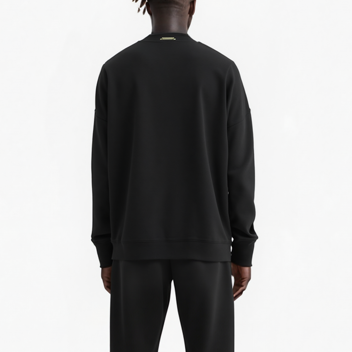 Person wearing a black sweatshirt and pants on a white background