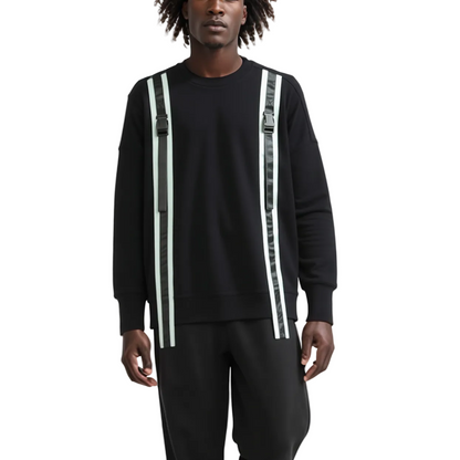 Person wearing a black outfit with suspenders on a white background