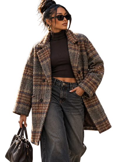 A woman wearing a brown and beige plaid wool-blend coat over a dark brown turtleneck, wide-leg gray jeans, and black sunglasses, carrying a dark brown handbag on a city street.