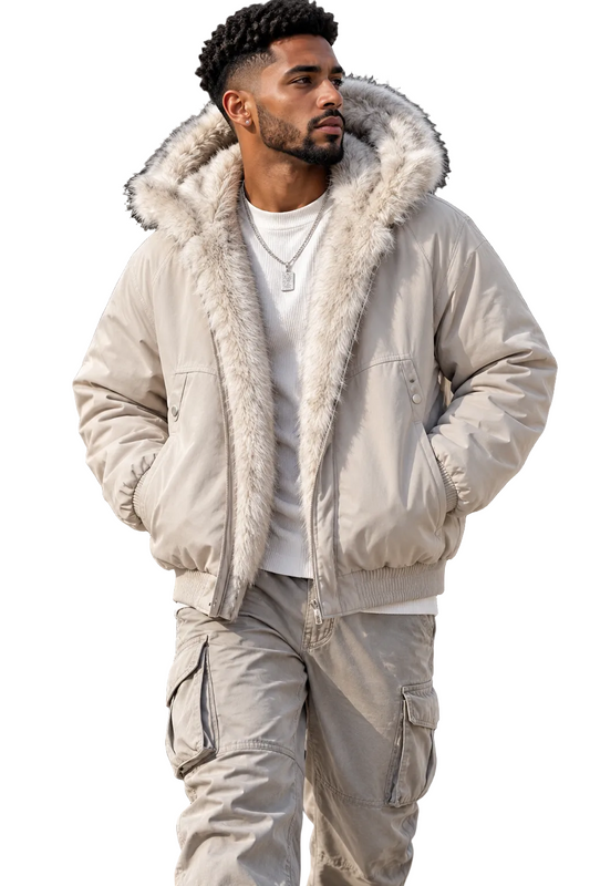 A man wearing a light beige puffer jacket with a fluffy faux-fur trimmed hood, styled over a white t-shirt and matching beige cargo pants, standing outdoors against a modern building facade.