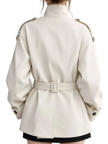 A person shown from the back wearing a cream-colored trench coat with a matching belt and silver-toned hardware, photographed against a plain light background.