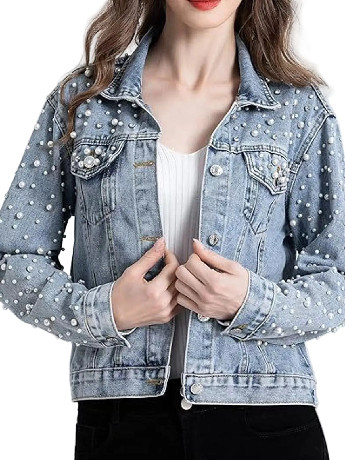A woman wearing a light-wash blue denim jacket embellished with white pearl-like studs, styled over a white ribbed top and black pants.