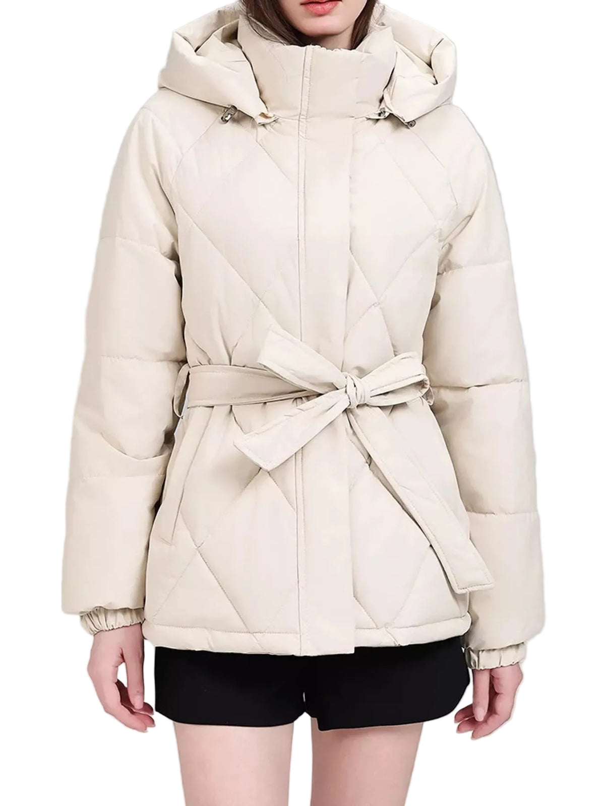 A woman wearing a quilted cream-colored hooded puffer jacket with a matching waist tie belt, paired with black shorts, against a plain light gray studio background.