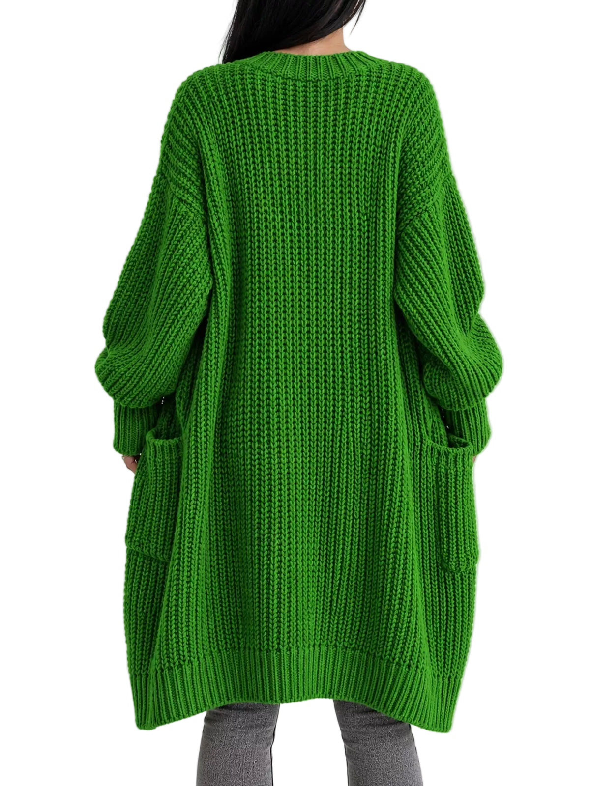 A person viewed from the back wearing an oversized bright green chunky knit sweater with long sleeves and side pockets, paired with gray pants, against a plain light background.
