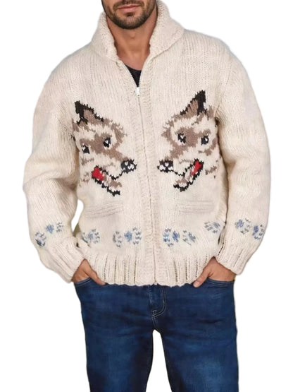 A man wearing a cream-colored knit zip-up sweater with a detailed dog design on the front, paired with blue jeans, standing in an open grassy field under a blue sky.
