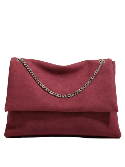 A burgundy suede clutch bag with a silver-tone chain strap, displayed against a clean white background.