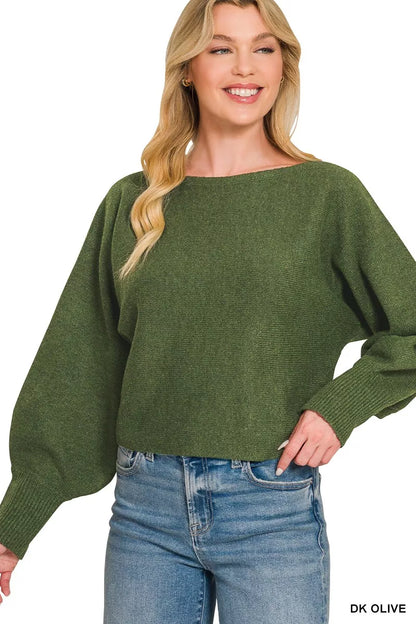 Woman wearing a green sweater and blue jeans on a white background