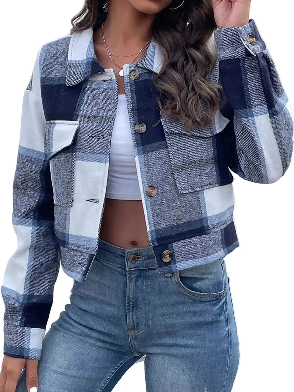 A woman wearing a cropped plaid jacket with navy, gray, and white blocks, paired with a white crop top and blue jeans.