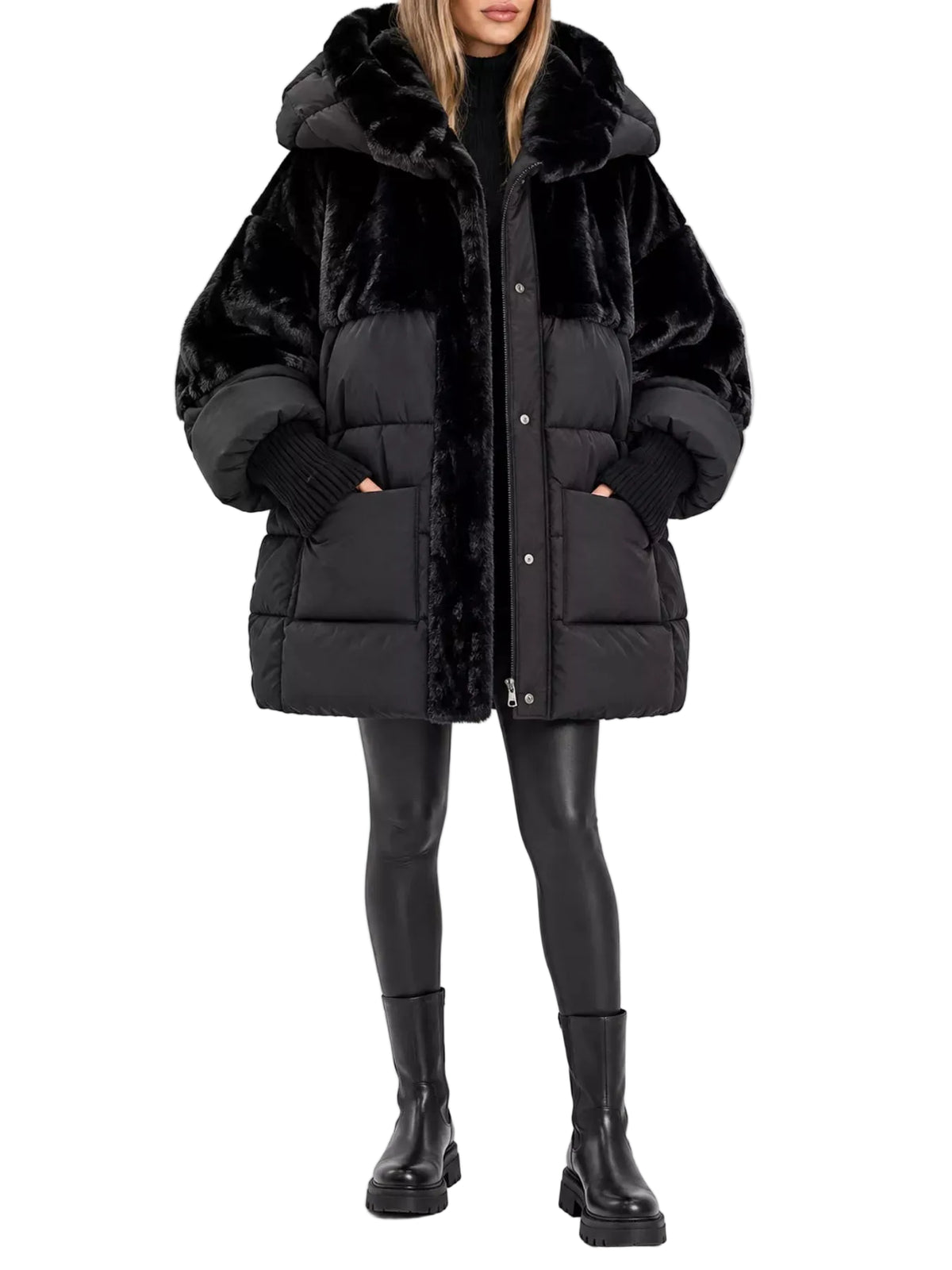 A model wearing a black faux fur and quilted puffer hybrid coat with a large plush hood, paired with black leggings and boots, against a plain white studio background.
