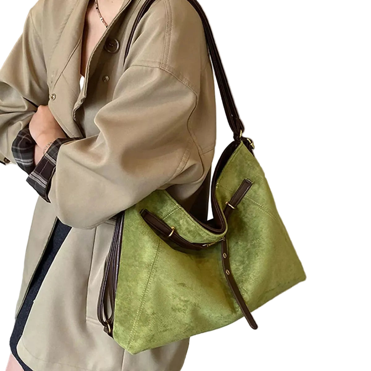 A person wearing a beige trench coat carries a large olive green suede-like shoulder bag with dark brown leather trim and straps in an indoor setting.