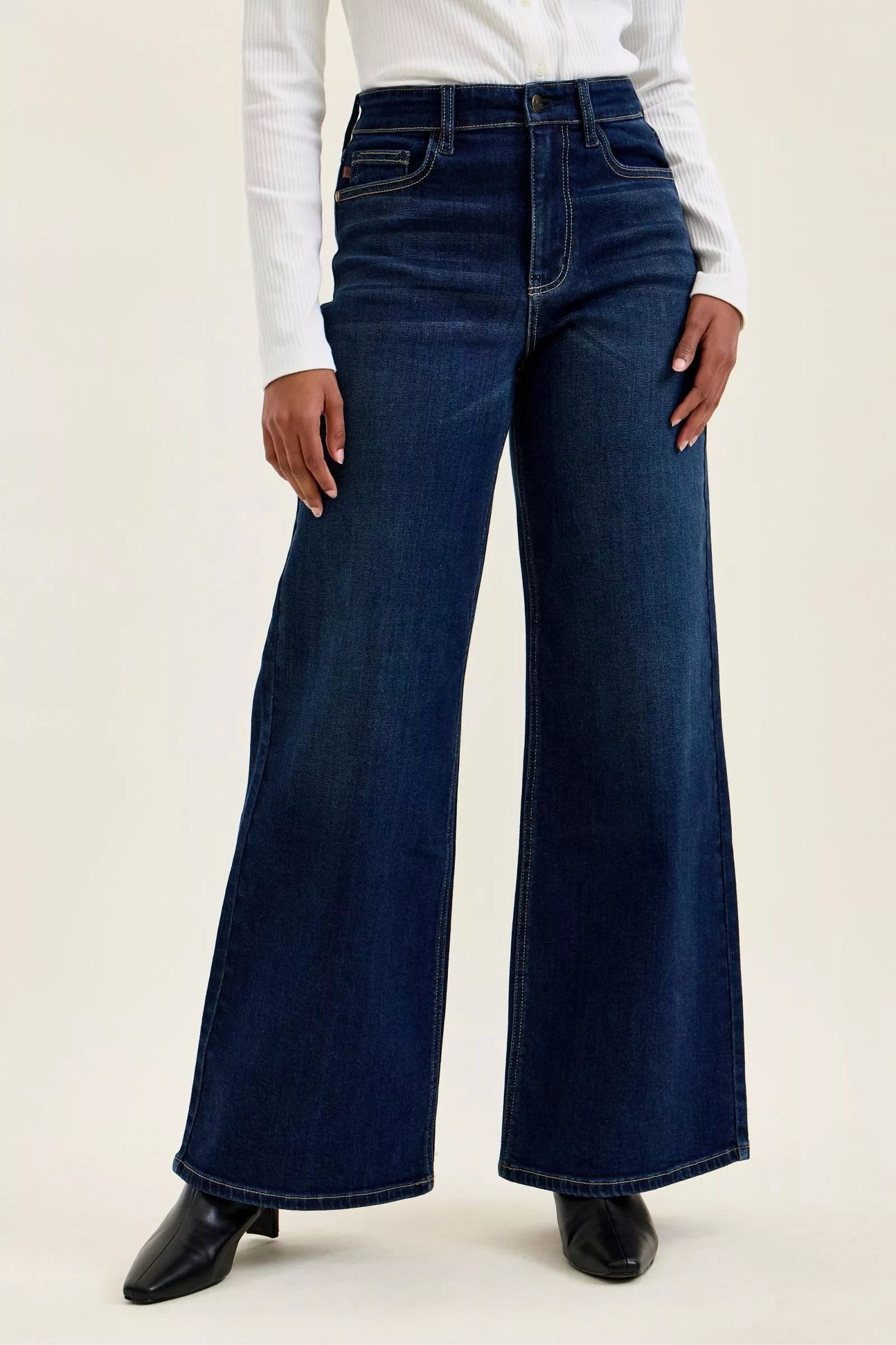 Person wearing blue wide-leg jeans on a plain background