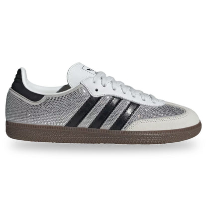 A low-top Adidas Samba sneaker featuring a silver rhinestone-embellished mesh upper, black three-stripes, a white leather toe cap and collar, and a brown gum sole, shown against a plain white background.