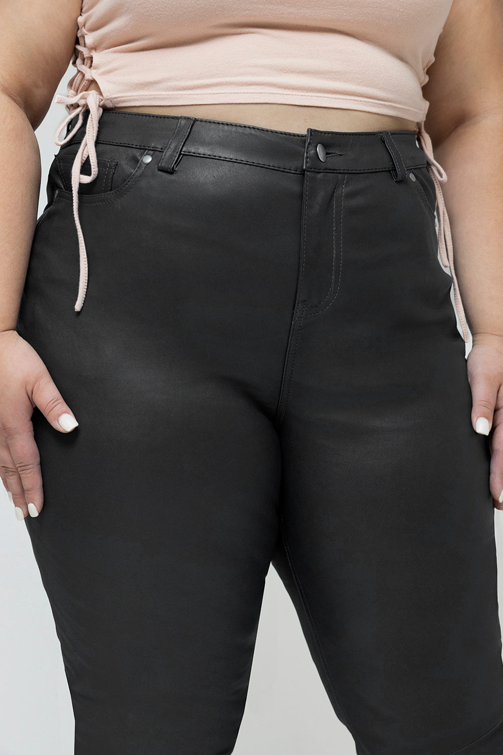 Person wearing black pants with a neutral background
