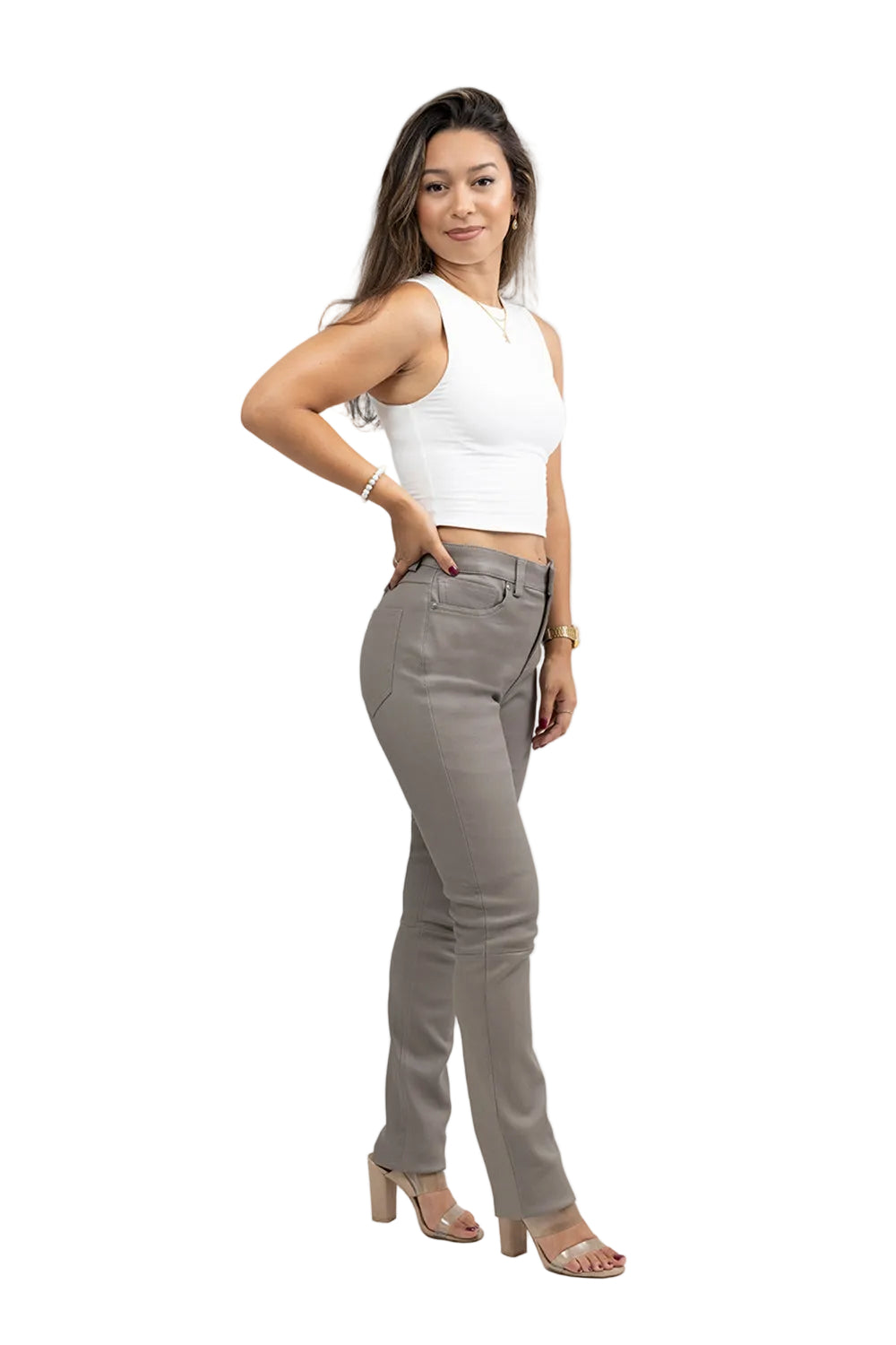 Woman wearing a white sleeveless top and gray pants on a light gray background