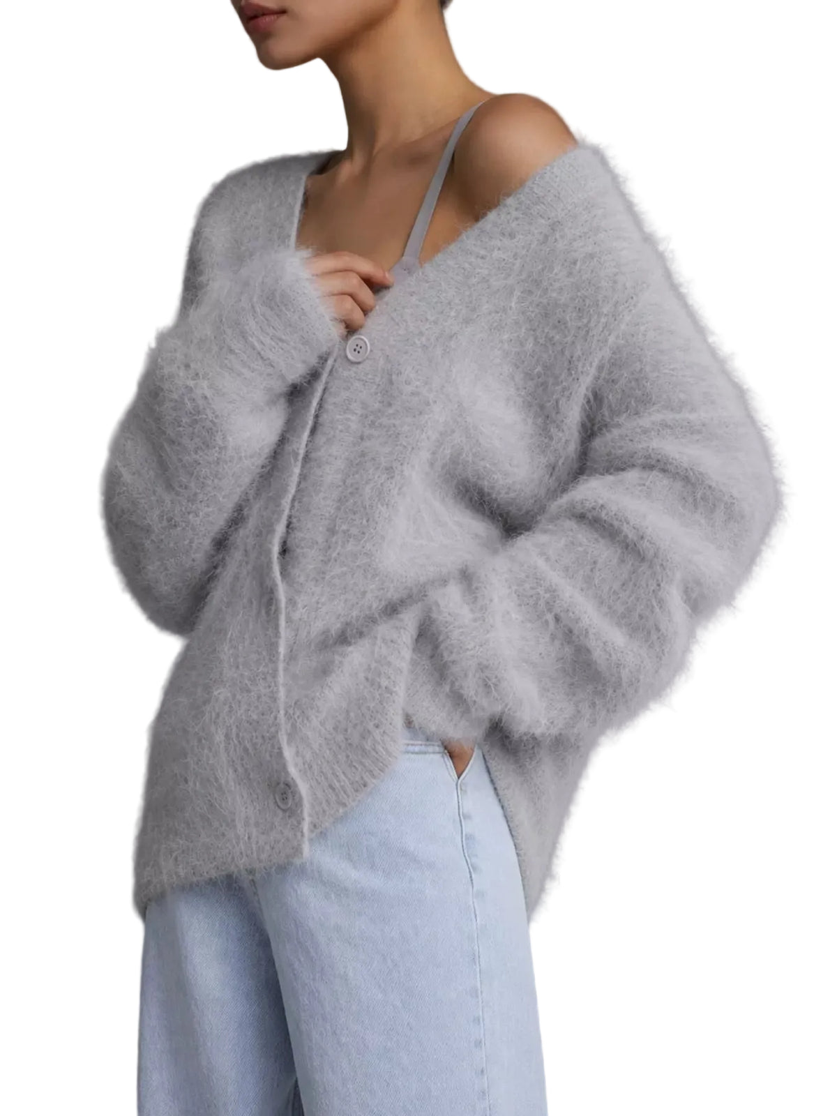 A model wearing a light gray fuzzy, oversized cardigan sweater over a light blue strapless top and light blue jeans, set against a solid gray studio background.