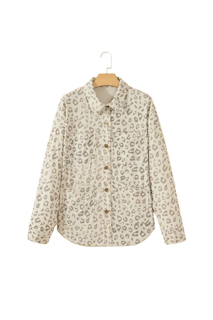 A long-sleeve button-up shirt with a beige and gray leopard print pattern, hanging on a wooden hanger against a solid beige background.