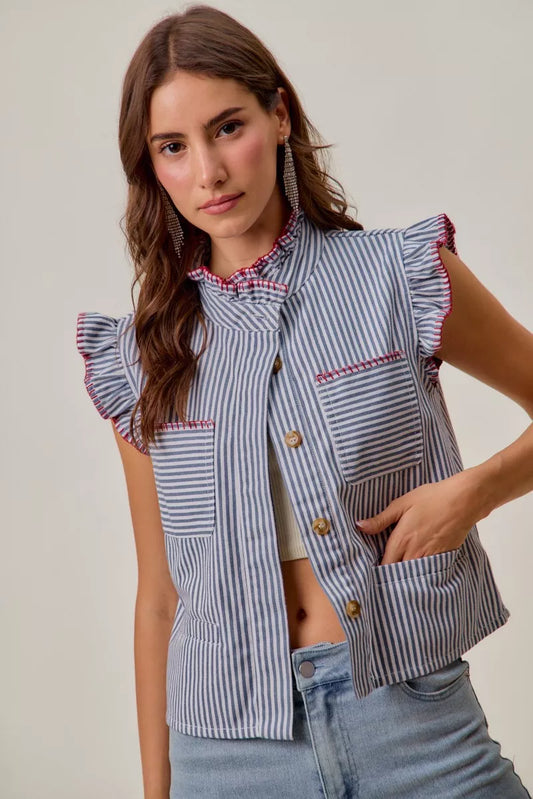 Woman wearing a blue and white striped vest with ruffled sleeves against a plain background
