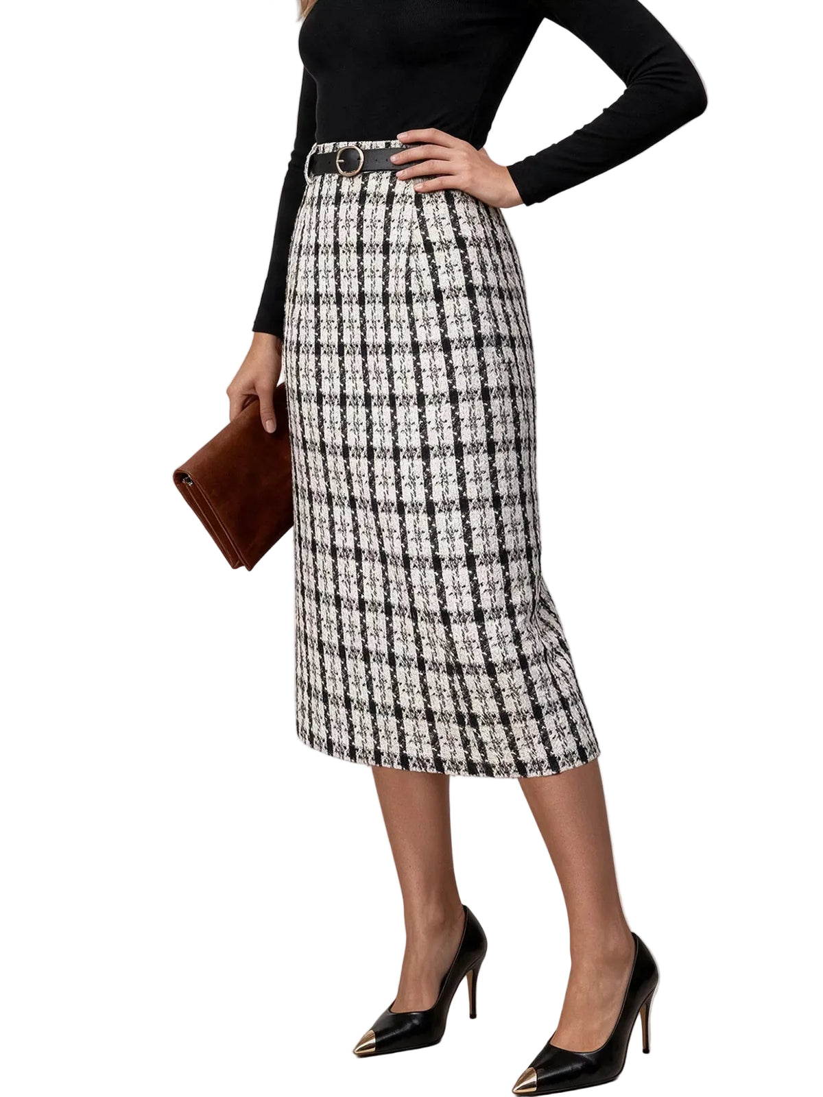 A woman models a black and white tweed pencil skirt with a black belt, paired with a black long-sleeve top, black pointed-toe heels with gold accents, and a brown clutch, set against a plain light gray studio background.