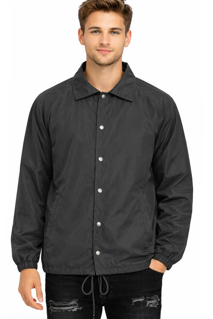 Man wearing a black coach's jacket on a white background