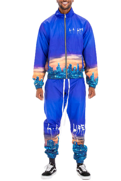 Person wearing a blue and purple jumpsuit with artistic designs on a white background